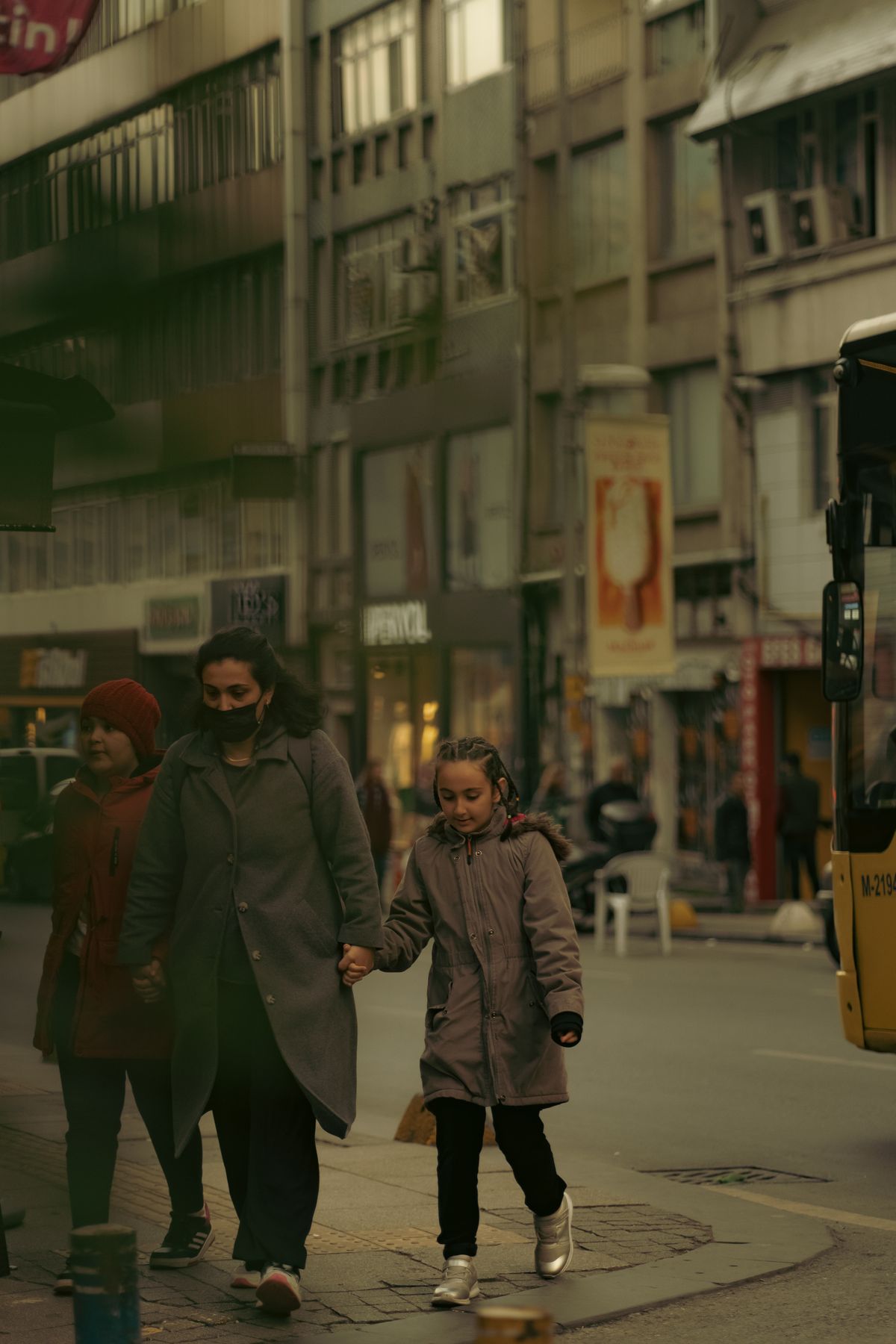 A mother and child walking hand in hand through town